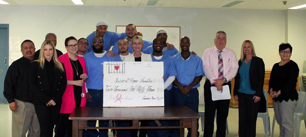 Group of incarcerated men and CPP volunteers with big check for breast cancer fundraiser