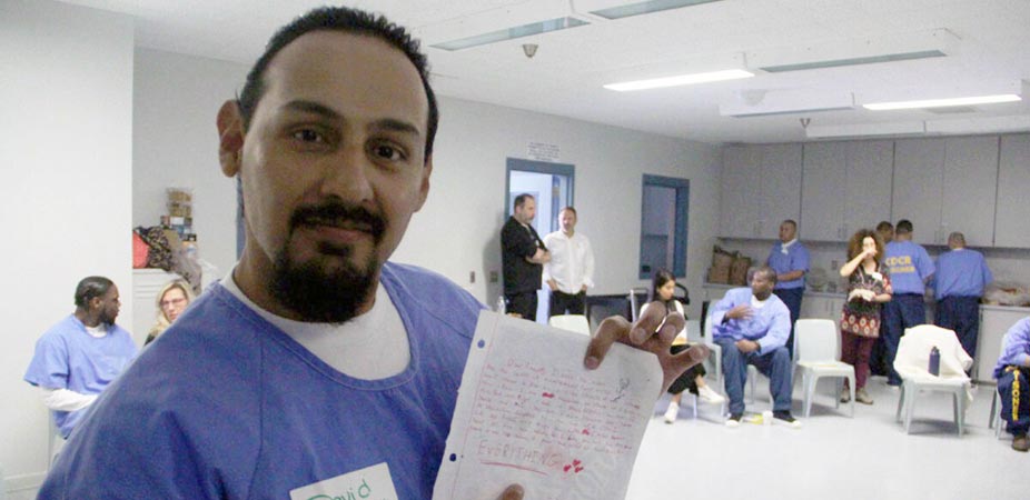 Man holding up a letter with drawn hearts on it smiling