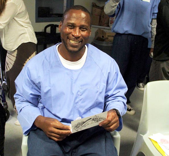 Man with big smile sitting down reading a letter