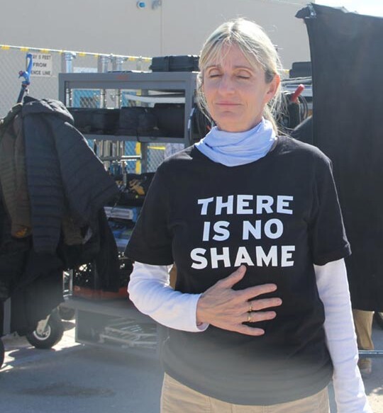 Fritzi Horstman standing with eyes closed and hand on stomach in moment of meditation