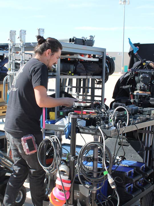 Man outside setting up filming equipment