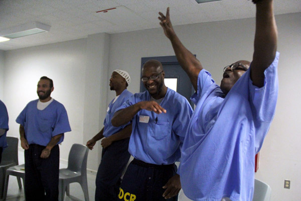 Incarcerated man with hands in the air celebrating