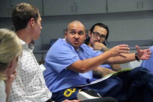 Incarcerated man talking about trauma while others intently listen