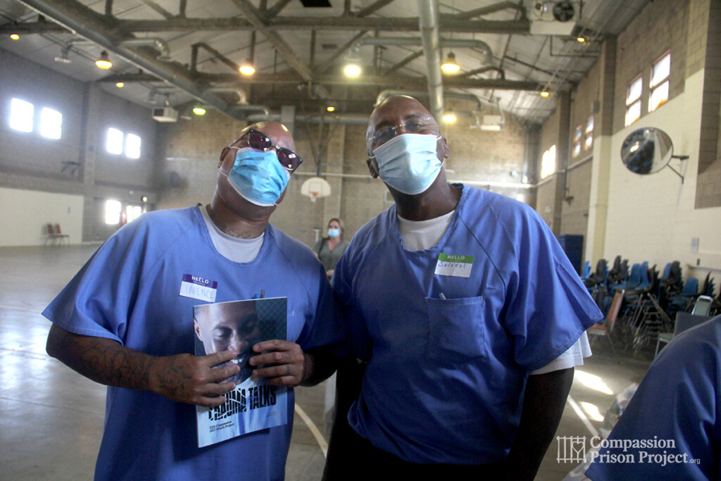 2 men in masks holding our workbook Trauma Talks